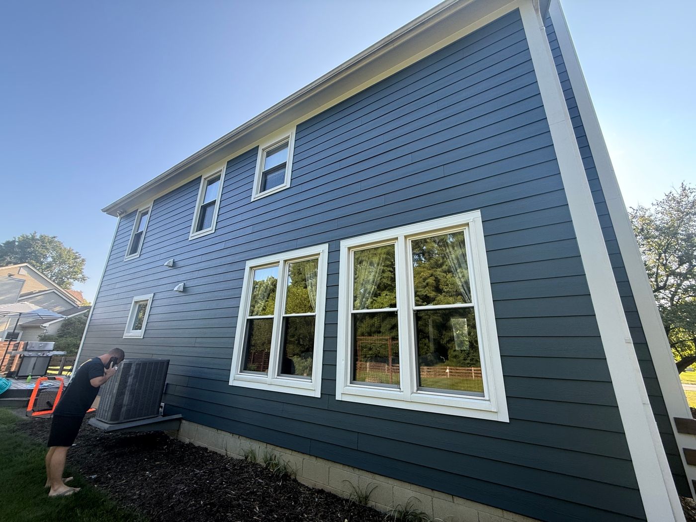 Rear elevation with new James Hardie lap siding and new white window trim